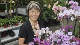 Kifumi Keppler, owner of Exotic Plants, with many blooming orchids.