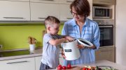 A mom and little boy collect kitchen scraps