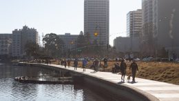people walk around Lake Merritt in Oakland