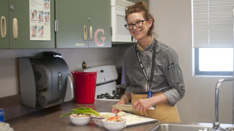 Home economics teacher Kathleen Albiani chops food in the middle school home ec classroom