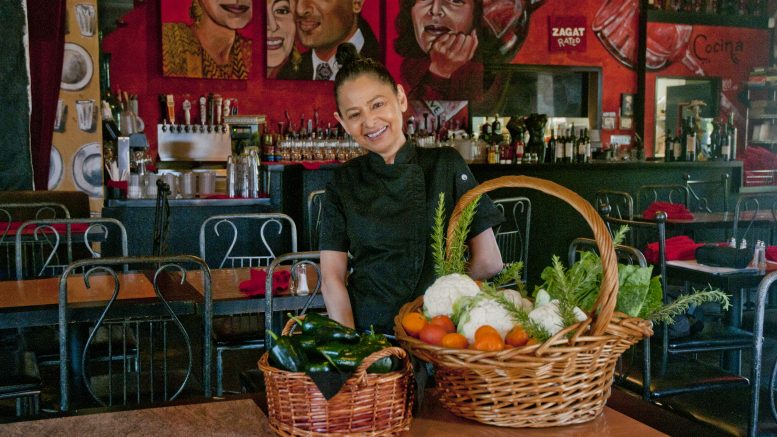 Marie Mertz,at her restaurant Todo Un Poco in Elk Grove, with a basket of fresh vegetables