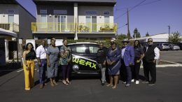 Members of The Fresno Metro Black Chamber of Commerce posing with one of their electric vehicles