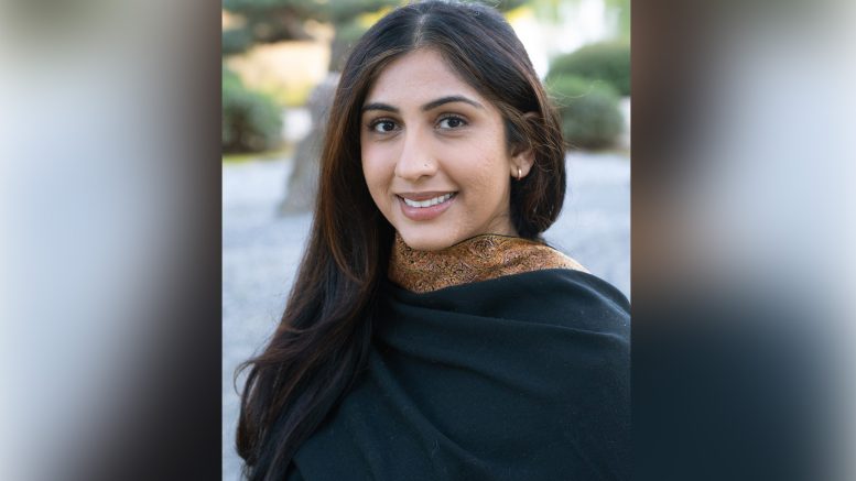A portrait of a woman, Jaskeet Kaur, outside, smiling.